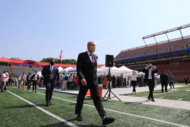 Governor Murphy, wearing a mask, walks on the field of SHI Stadium at Rutgers